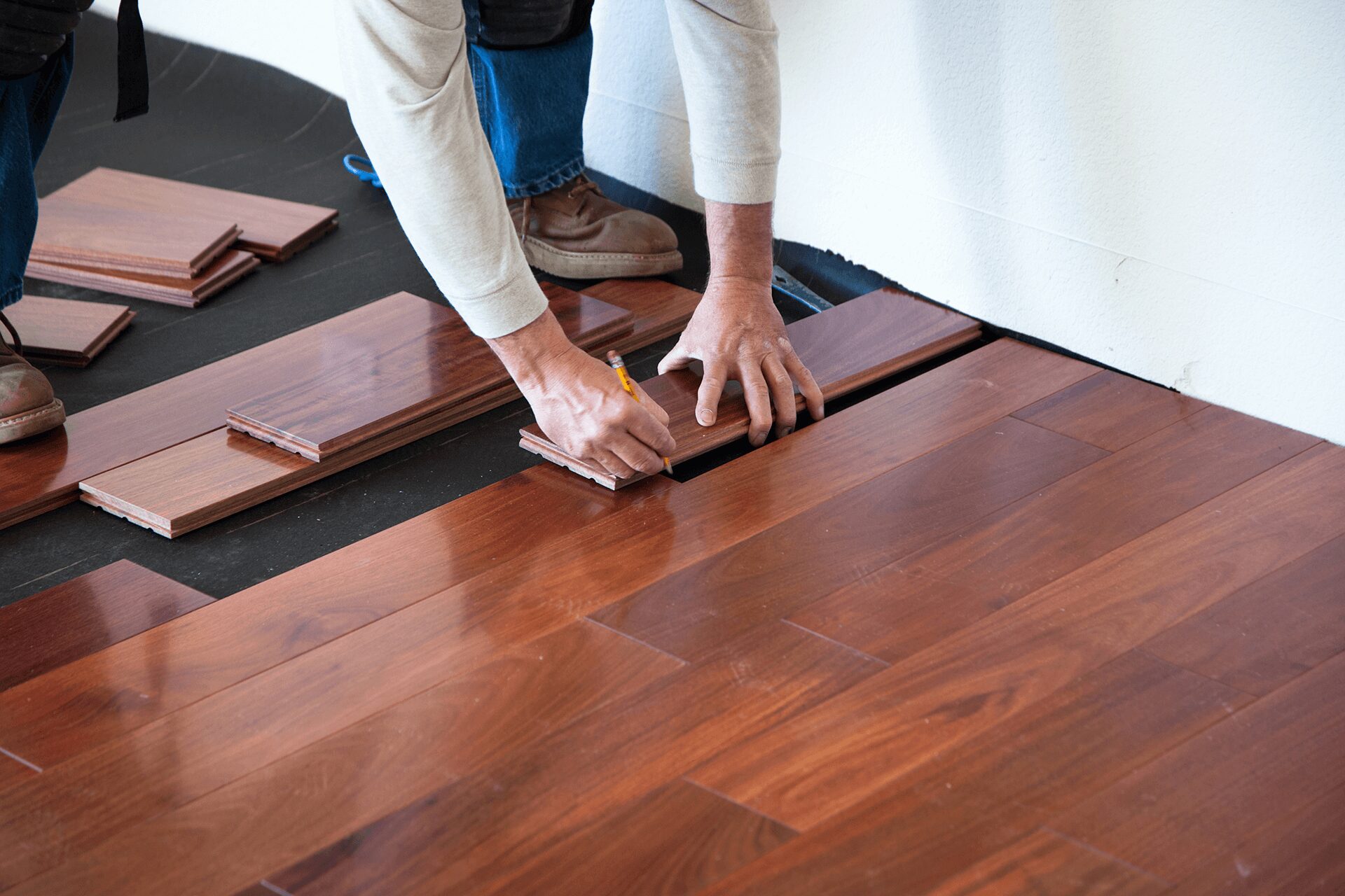 Installing wooden flooring with precise measurement.