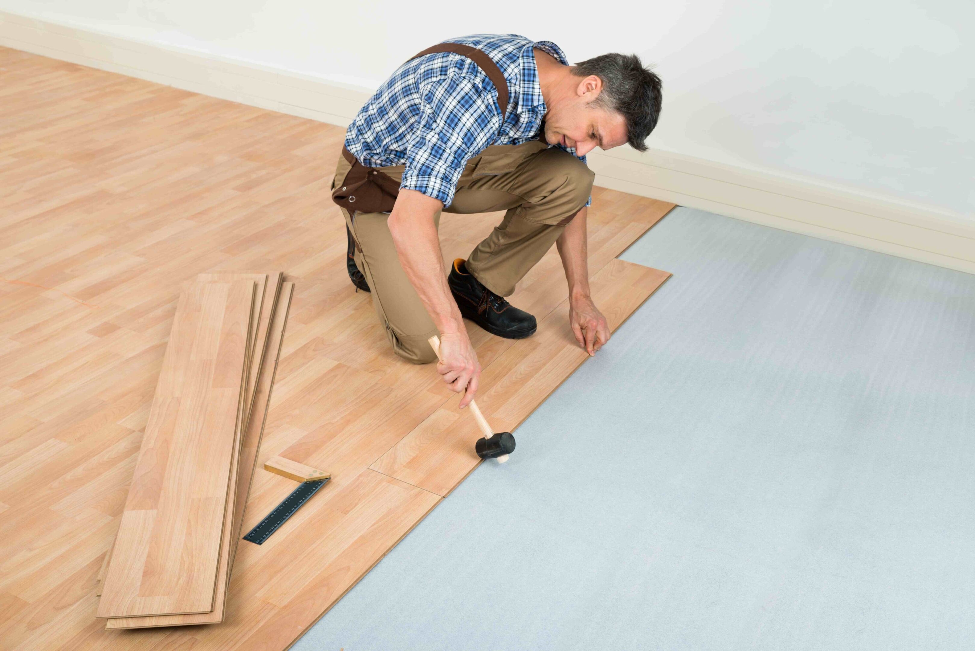 Man installing wooden laminate flooring.